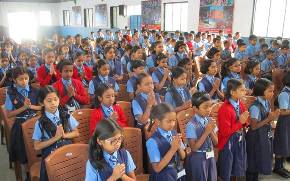 Students gathered in a classroom or hall for a prayer session